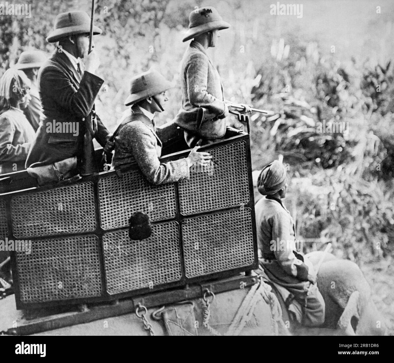 Nepal:    January 29, 1922 The Prince of Wales watches from his howdah atop an elephant for any big game to break cover while on his hunting expedition in the jungles of Nepal. His gun loaders are in the howdah with him. Stock Photo