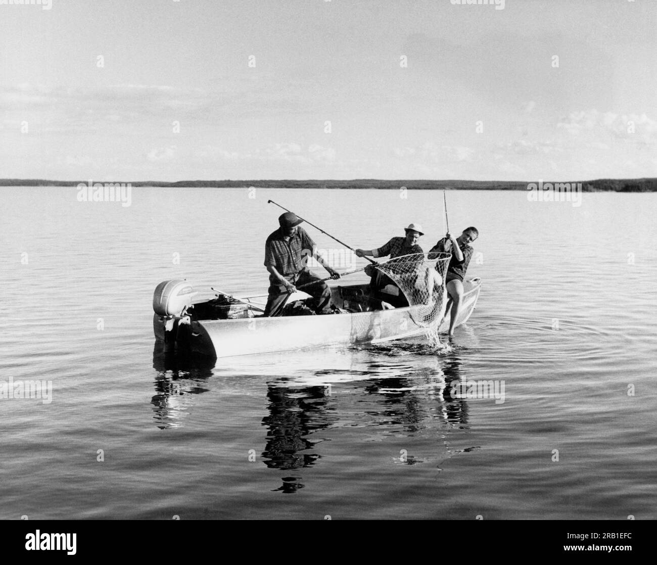 La Ronge, Saskatchewan, Canada:  c. 1960 Fishermen landing a big lake trout on Lac La Ronge in Canada. Stock Photo