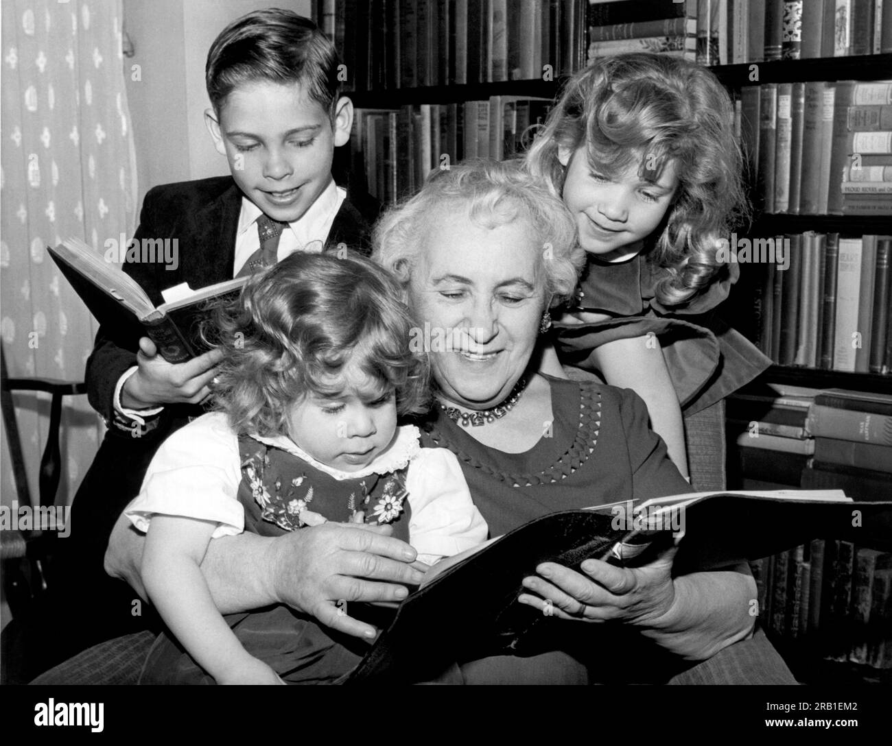 New York, New York:  May 16, 1964 This 69 year old grandmother is back at school as a member of the New School's Institute for Retired Professionals. Her grandchildren are assisting her with her homework. Stock Photo