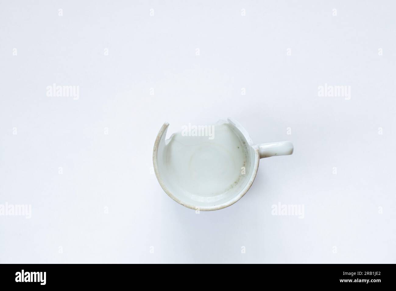 white broken cup on white background close up Stock Photo - Alamy