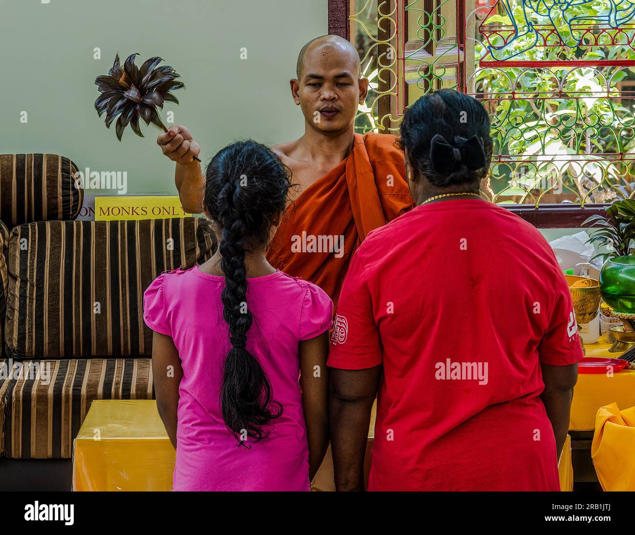 Penang, Malaysia Photo of a Budhist monk blessing a woman and a