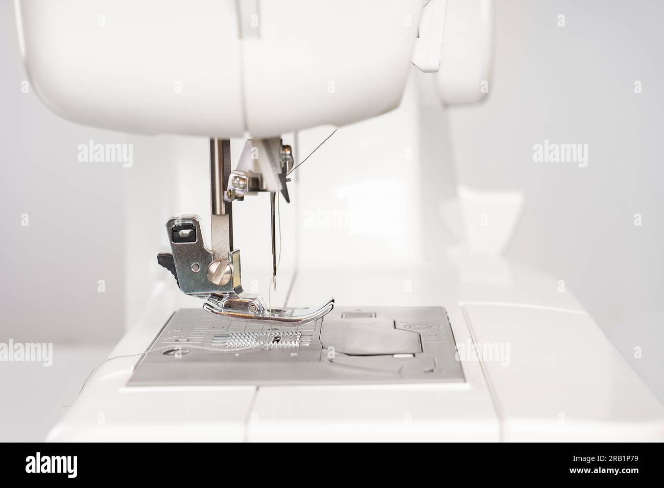 Modern white sewing machine presser foot closeup, macro. Sewing