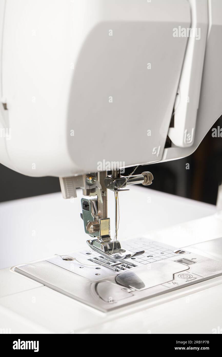 Modern white sewing machine presser foot closeup, macro. Sewing