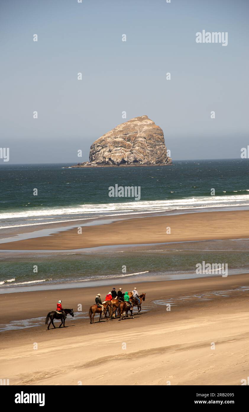 Horseback riders follow the coast along the beach of Neskowin, Oregon. Stock Photo