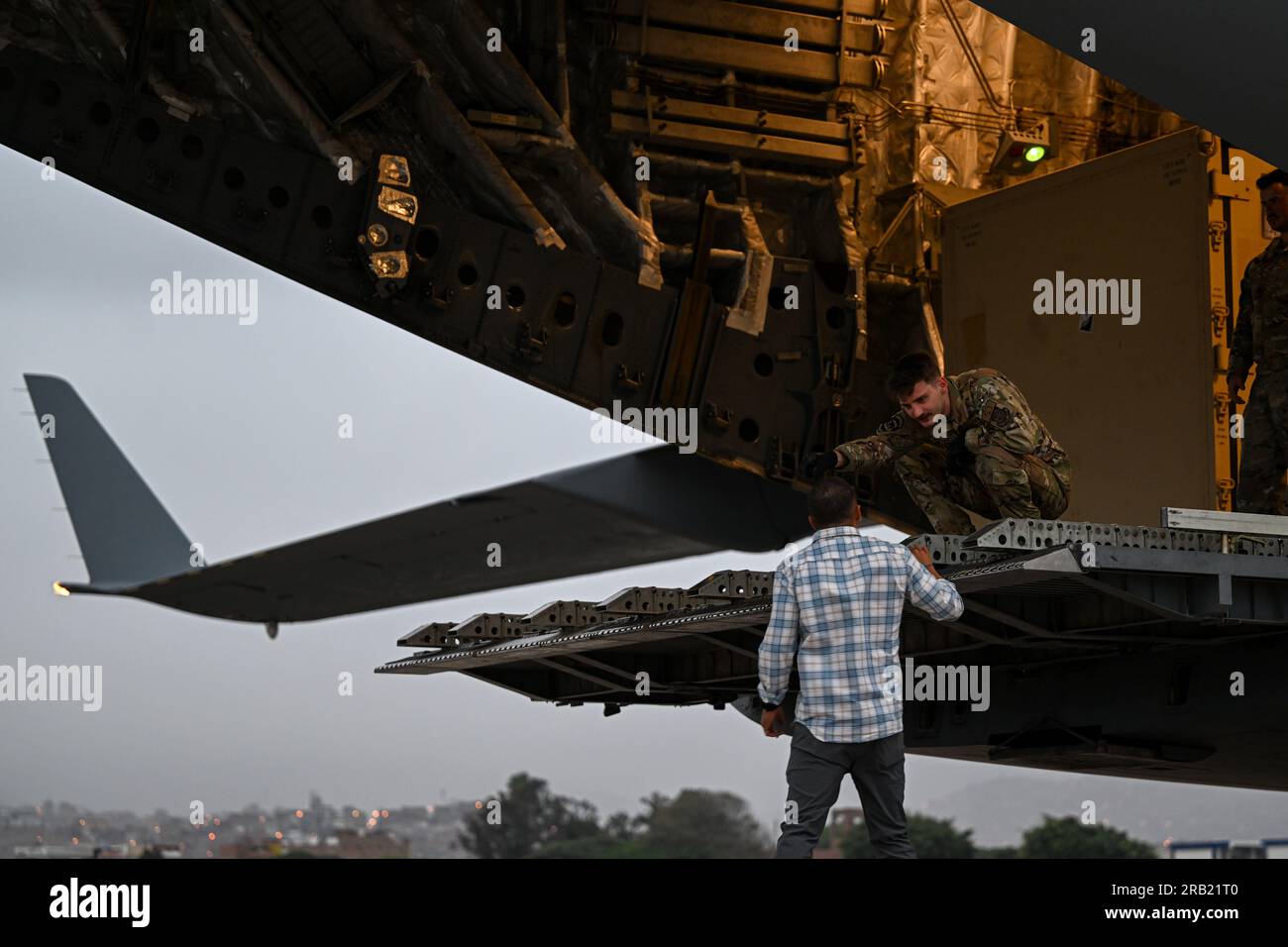 A U.S. Air Force loadmaster assigned to the 6th Airlift Squadron, Joint Base McGuire-Dix-Lakehurst, New Jersey, unloads a C-17 Globemaster III at Las Palmas Air Base, Lima, Peru, July 5, 2023 during exercise Resolute Sentinel 23. Resolute Sentinel improves readiness of U.S. and partner nation military and interagency personnel through joint defense interoperability training, engineering projects and knowledge exchanges. (U.S. Air Force photo by Master Sgt. Corban Lundborg) Stock Photo