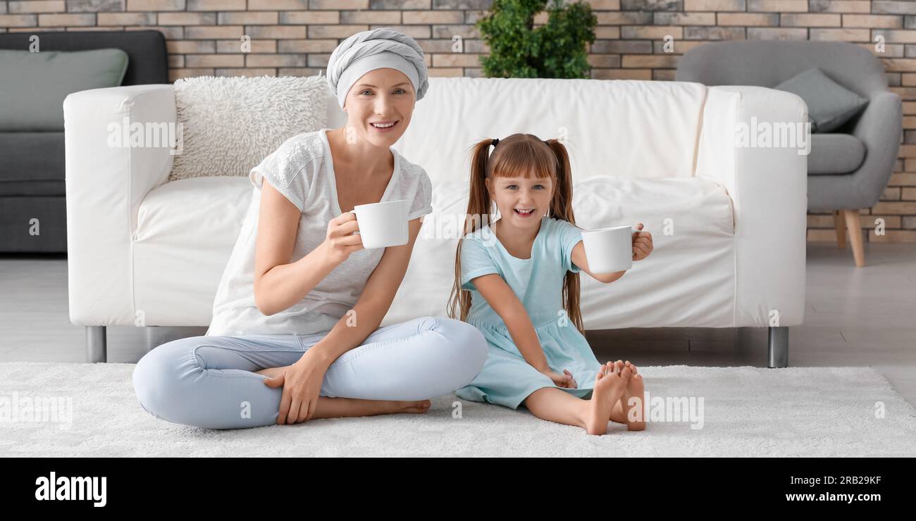 Little girl and her mother after chemotherapy drinking tea at home