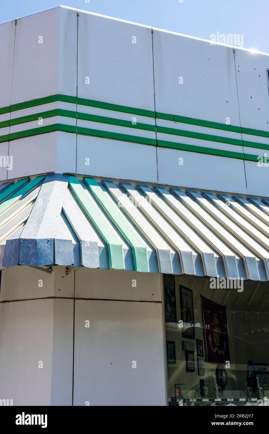 Green & white architecture on retro vintage building shows new or refurbished awning at corner with window. May be old gas station business. Stock Photo