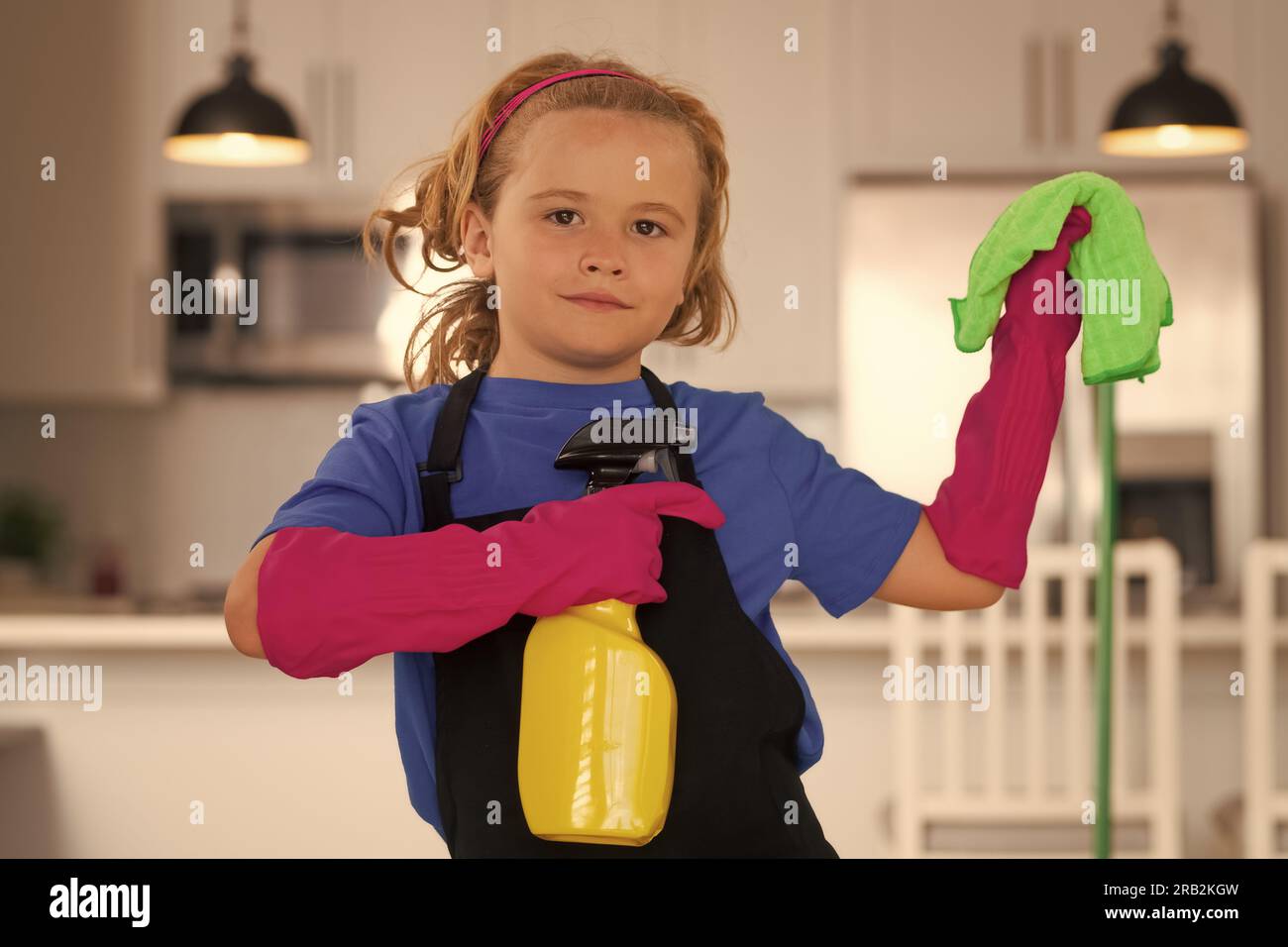 Cleaning house. Child use duster and gloves for cleaning. Funny child mopping house Stock Photo