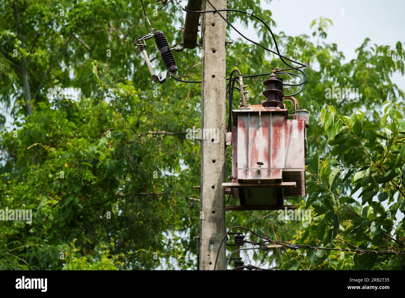 old three-phase transformer with electric pole Stock Photo