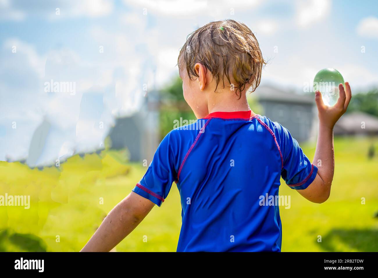 Young Caucasian boy taking aim to throw a water balloon Stock Photo Alamy