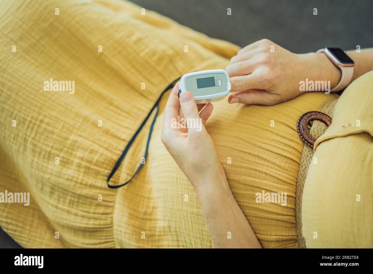 Pregnant woman with pulse oximeter on finger. Doctor measuring oxygen
