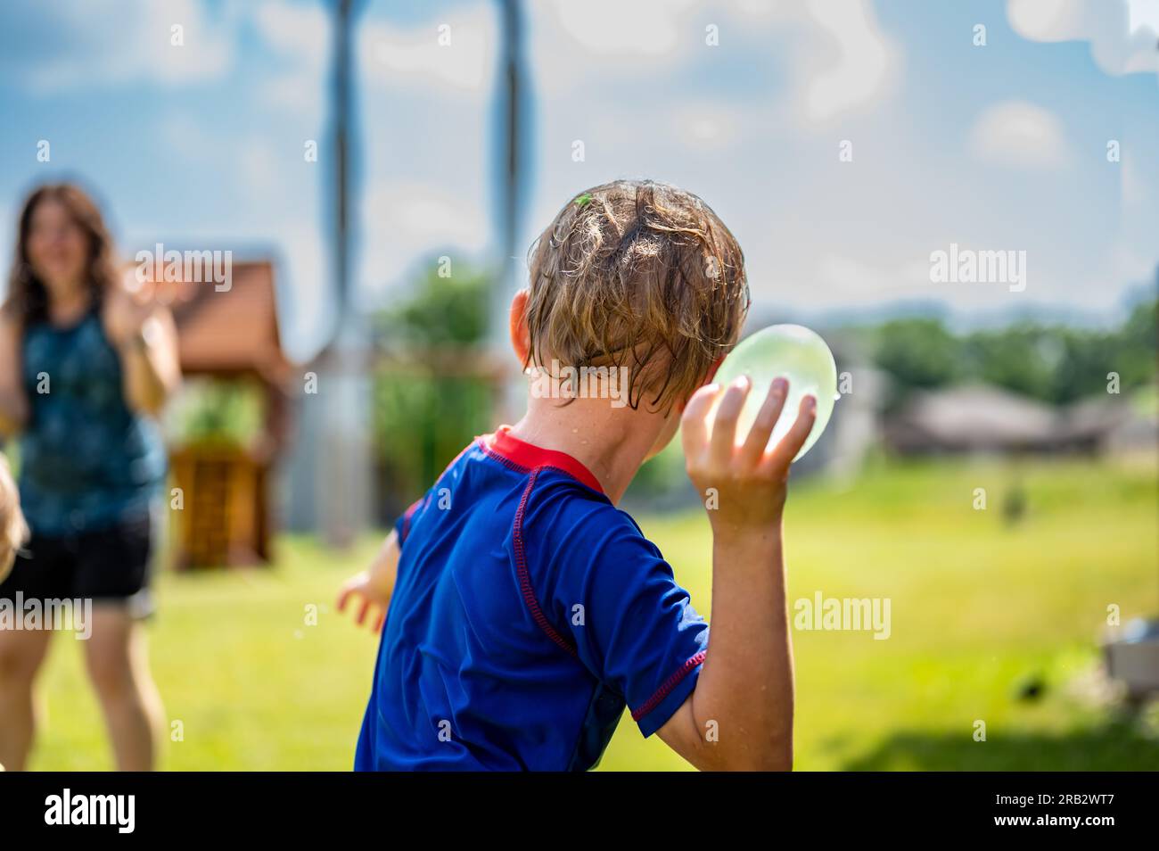 Young Caucasian boy taking aim to throw a water balloon Stock Photo Alamy