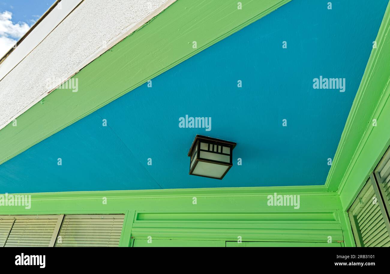 A lamp on the exterior blue ceiling above the entrance to a building