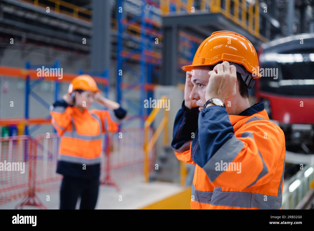 Engineer team worker check safety helmet clothing for work electric train service depot transport industry factory technician mechanic staff. Stock Photo
