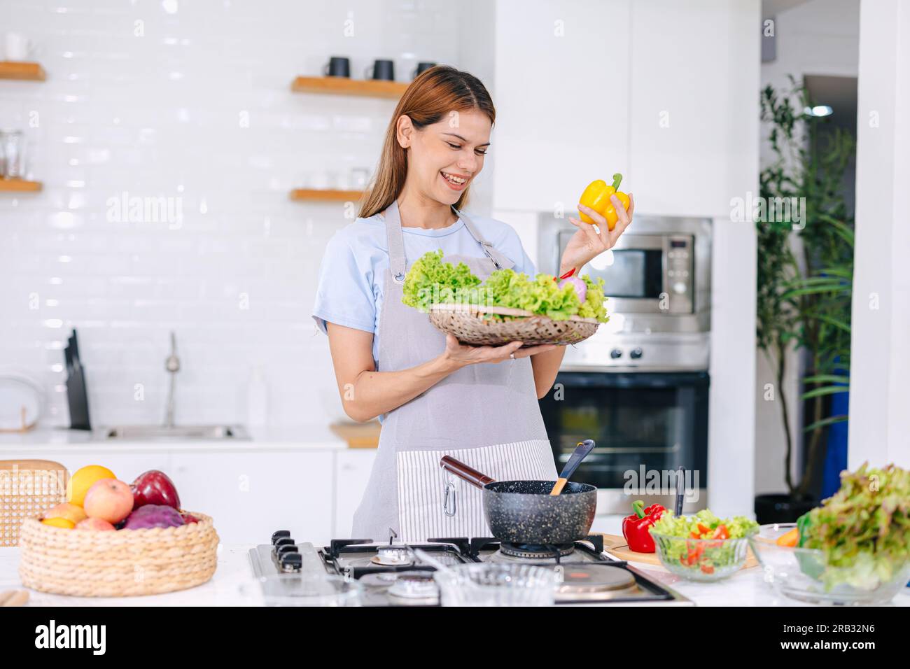 Happy Young Woman Making Salad. People Eating Healthy Food. Vegan Lady In Kitchen Home. Eat Vegetable For Dieting. Prepare Diet Meal At Island Stove. Stock Photo