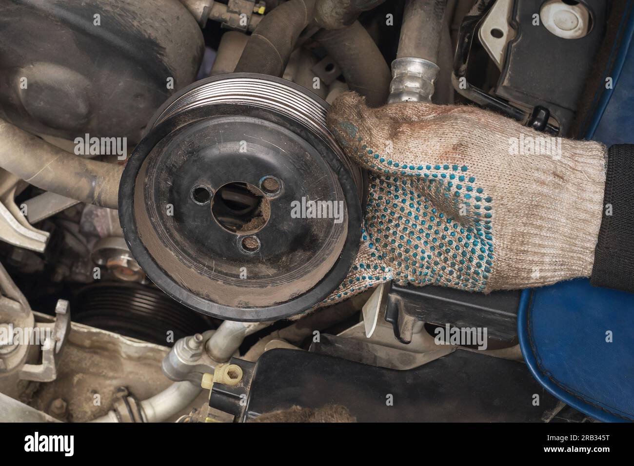 An auto mechanic removed an old pulley from a car engine to replace it