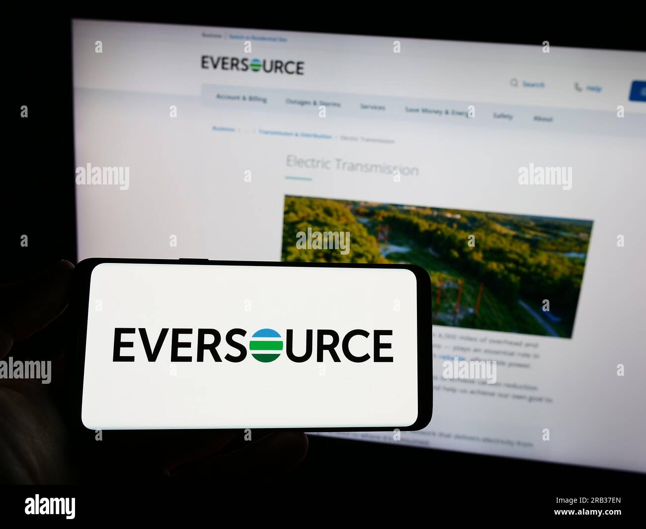 Person holding smartphone with logo of US utility company Eversource Energy on screen in front of website. Focus on phone display. Stock Photo