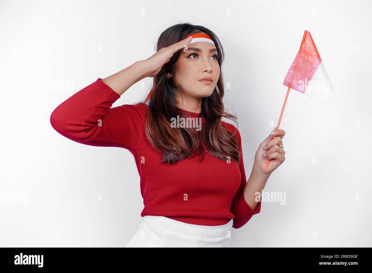 Beautiful Asian woman giving salute celebrate Indonesian independence day on August 17 isolated over white background Stock Photo