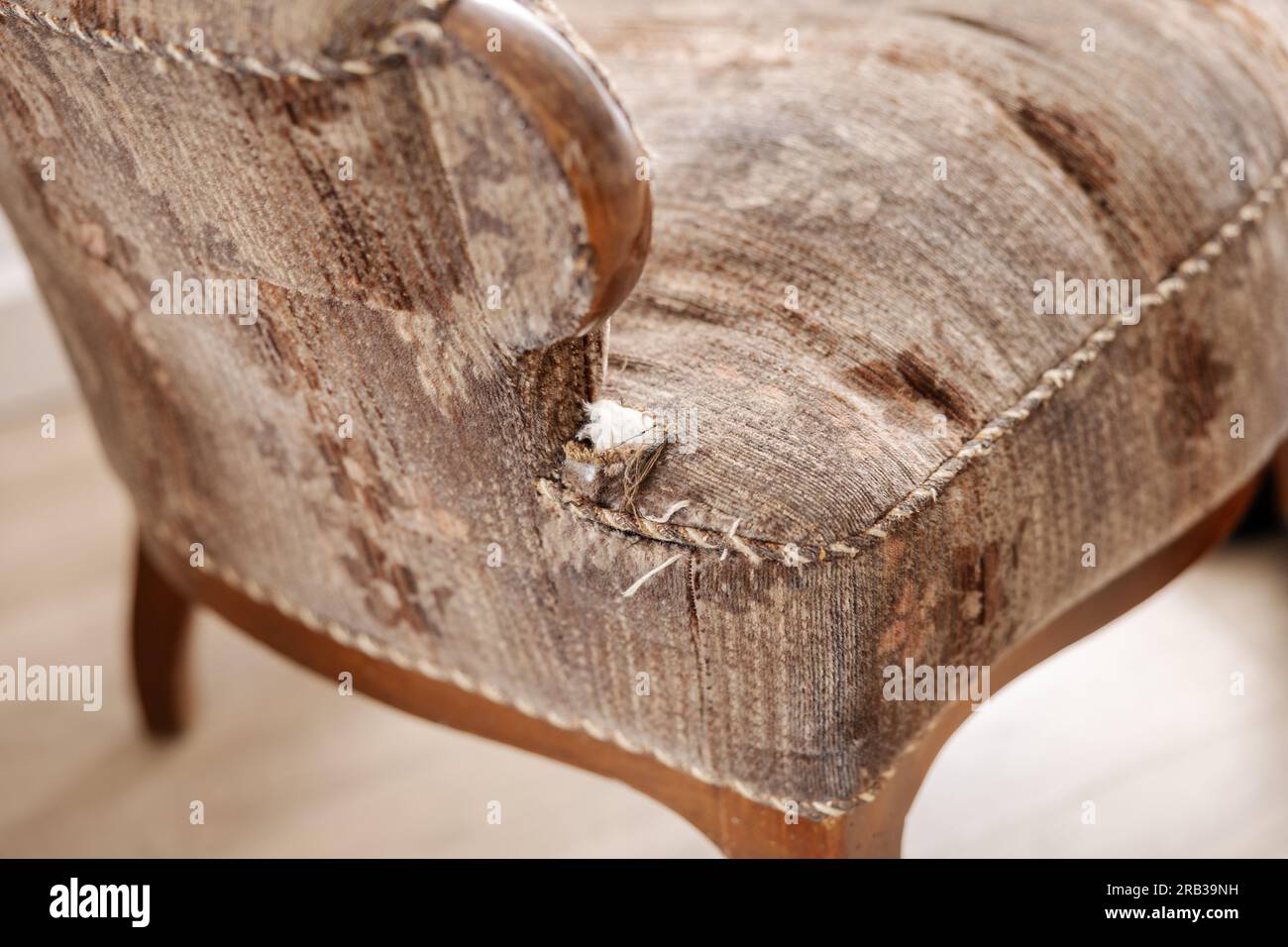 Old, damaged vintage armchair with holes in seat. Antique couch with