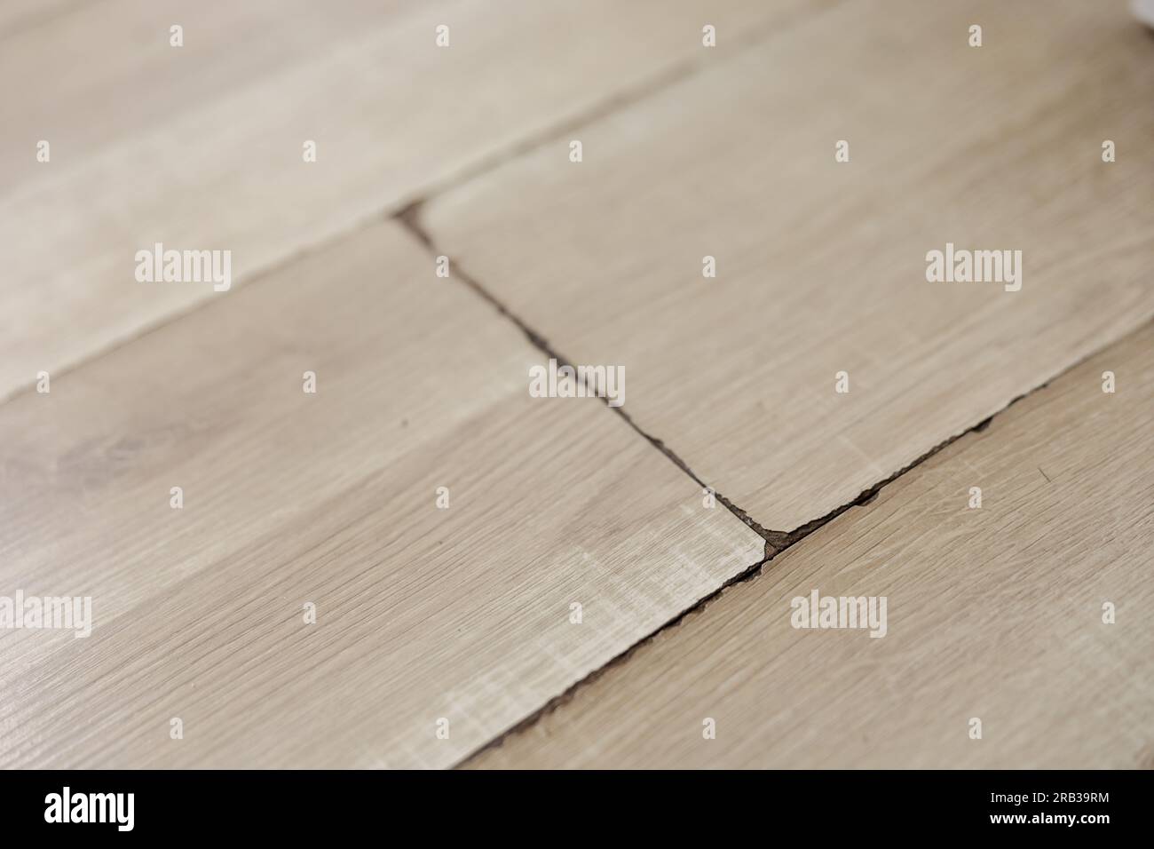 Swollen and dirty laminate floor, close up view. Moisture damage