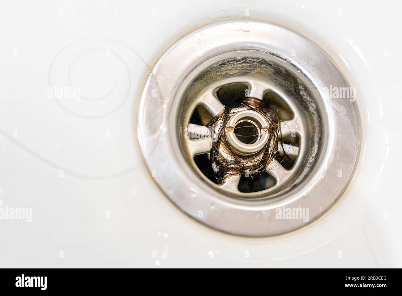 Closeup of long hair blocking the drain in the bathroom. Hair in the