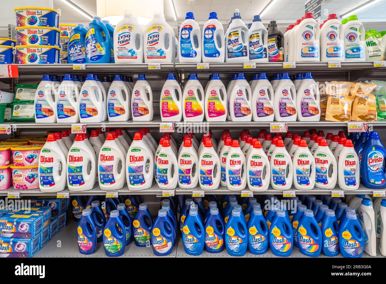 Italy - July 06, 2023: Washing machine detergents in plastic bottles of different types and brands on the shelf for sale in an Italian supermarket Stock Photo