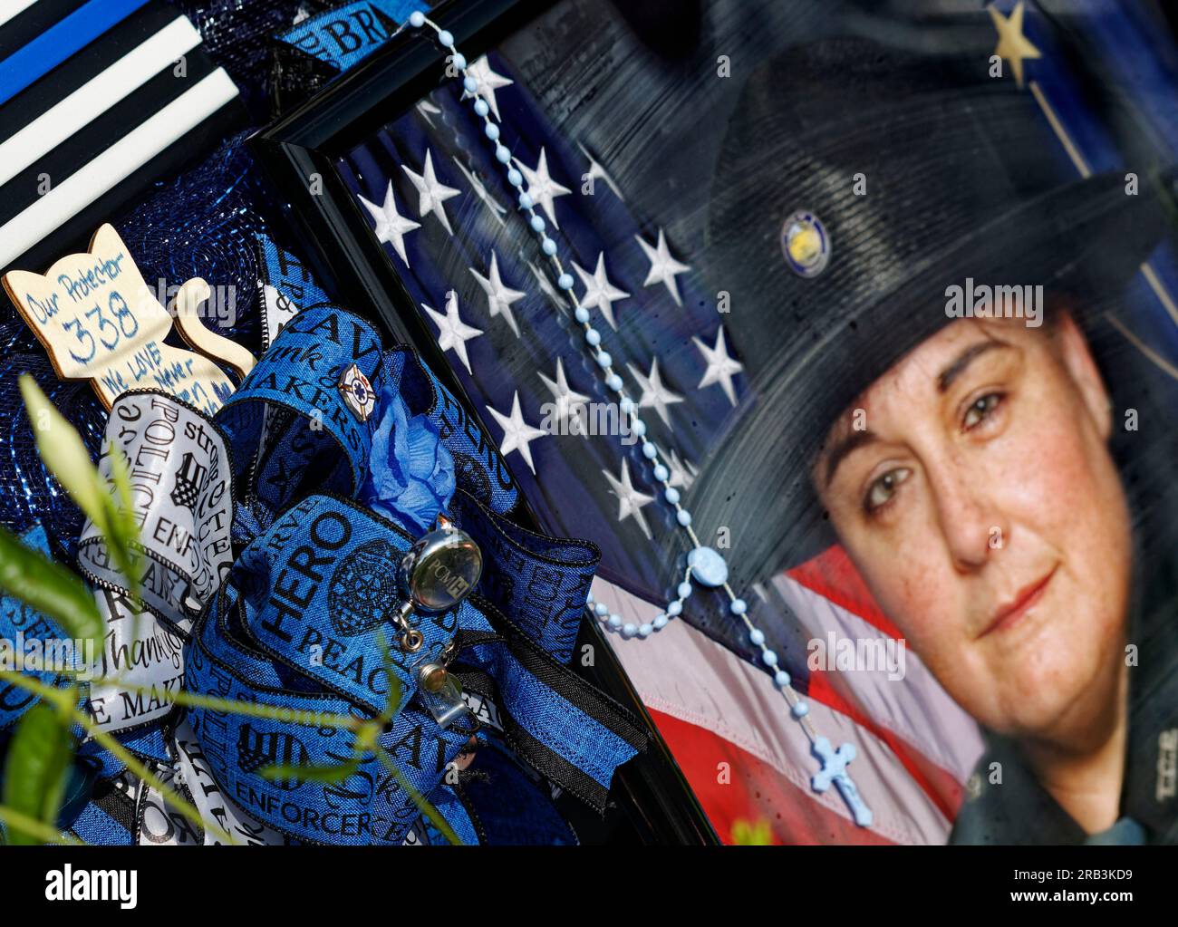 A photograph of Tell City Police Department Sgt. Heather J. Glenn leans against the front of her Dodge Durango patrol vehicle with memorial tributes piled around it on Thursday, July 6, 2023 near city hall in Tell City, Troy Township, Perry County, IN, USA. Glenn, 47, was shot and killed July 3 while trying to arrest a domestic violence suspect at a local hospital, becoming the first line-of-duty death in the Tell City Police Department's nearly 165-year history and second Indiana police officer to be killed in the line of duty in less than a week. (Apex MediaWire Photo by Billy Suratt) Stock Photo