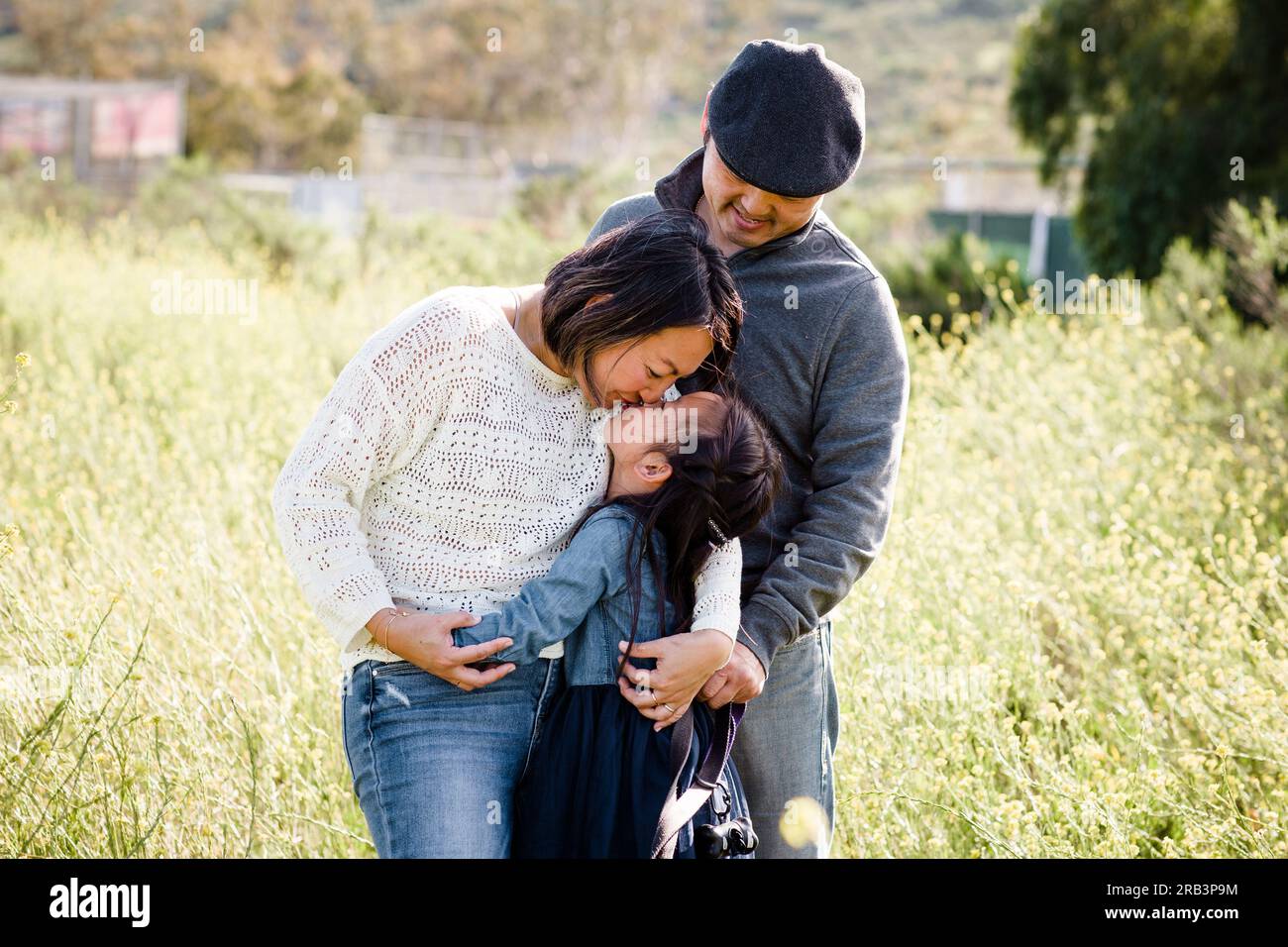 Asian Family of Three Standing in Wildflower Field in San Diego Stock