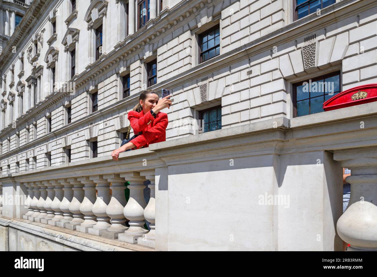 London, England, UK. Young woman in red taking a selfie in Parliamnt
