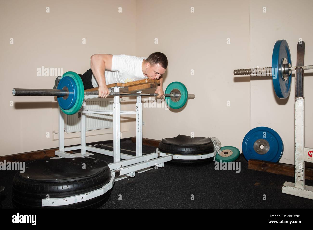 A man seen doing strength training with a barbell. Training and