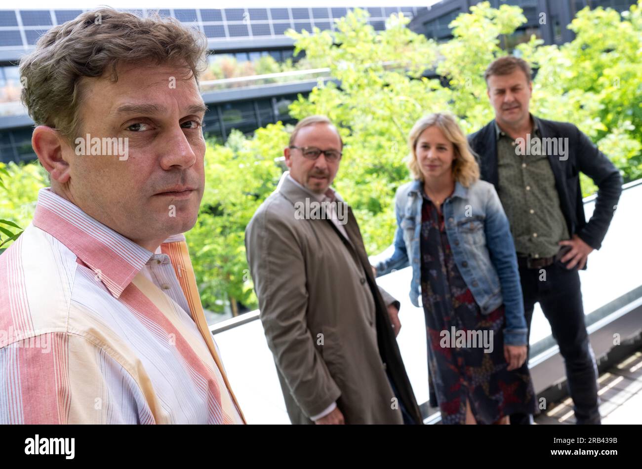 PRODUCTION - 06 July 2023, Bavaria, Munich: Sebastian Bezzel as Max Hämmerle (l-r), Alexander Held as Inspector Ludwig Schaller, Bernadette Heerwagen as Inspector Angelika Flierl and Marcus Mittermeier as Inspector Harald Neuhauser stand during a photo session on the film set of the crime series 'München Mord. Sebastian Bezzel will soon be a guest star on the ZDF series 'München Mord'. This week, filming took place in Munich-Schwabing. In the case with the working title 'Nix für Angsthasen' Bezzel plays a citizen who was once celebrated in the press as an everyday hero: Matthias Hämmerle had p Stock Photo