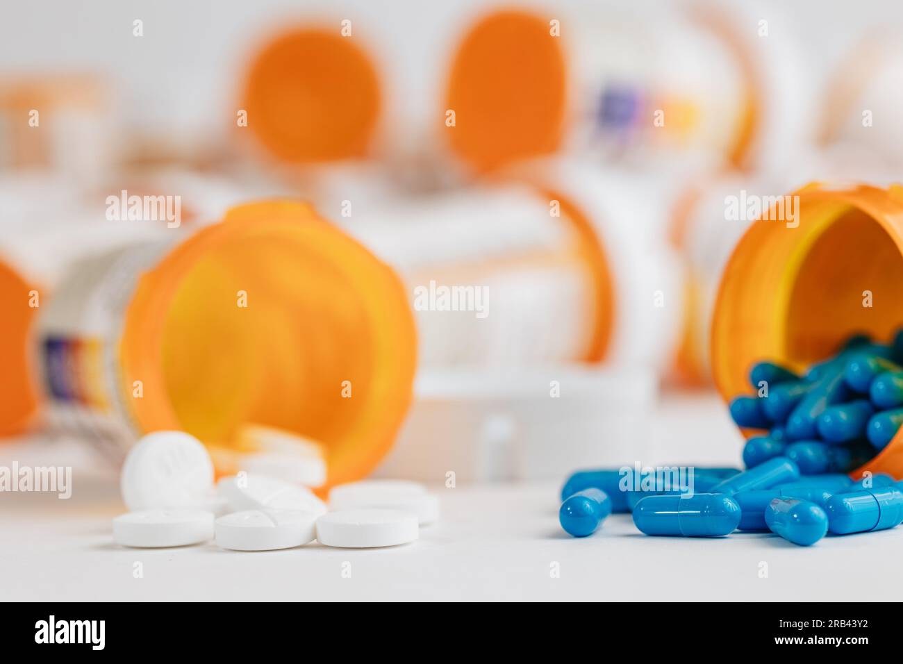 blue and white pills coming out of prescription pill bottles with