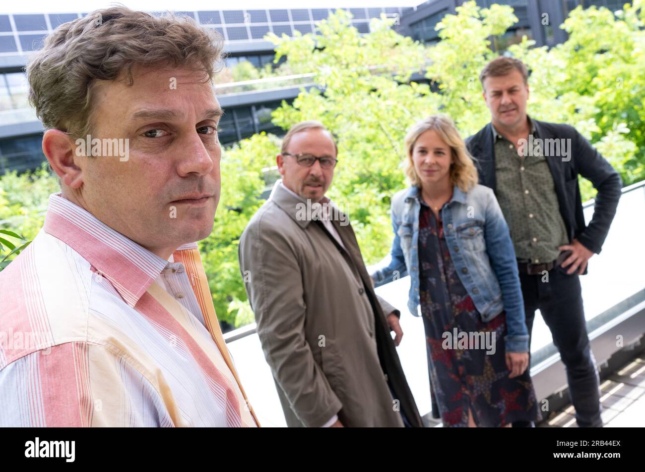 PRODUCTION - 06 July 2023, Bavaria, Munich: Sebastian Bezzel as Max Hämmerle (l-r), Alexander Held as Inspector Ludwig Schaller, Bernadette Heerwagen as Inspector Angelika Flierl and Marcus Mittermeier as Inspector Harald Neuhauser stand during a photo session on the film set of the crime series 'München Mord. Sebastian Bezzel will soon be a guest star on the ZDF series 'München Mord'. This week, filming took place in Munich-Schwabing. In the case with the working title 'Nix für Angsthasen' Bezzel plays a citizen who was once celebrated in the press as an everyday hero: Matthias Hämmerle had p Stock Photo