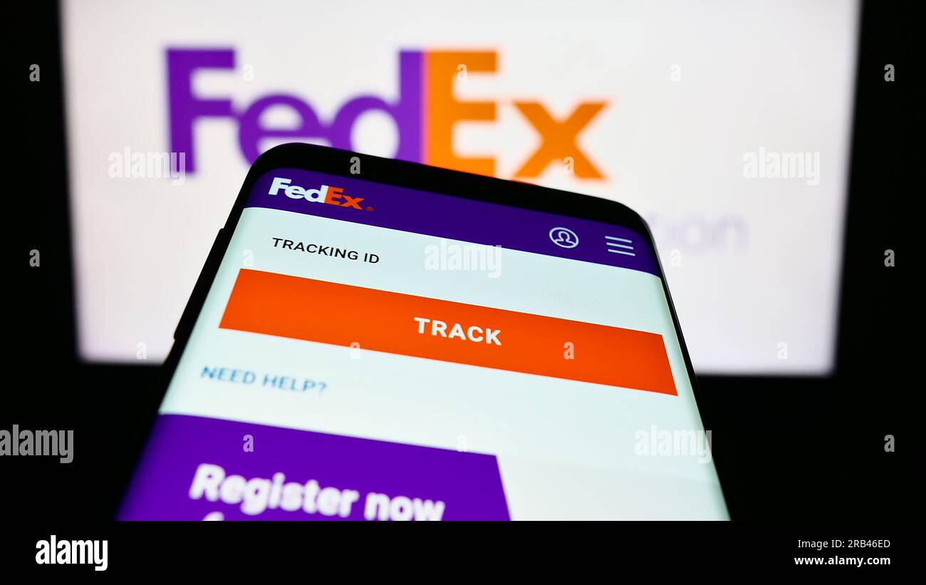 Smartphone with webpage of US logistics company FedEx Corporation on screen in front of business logo. Focus on top-left of phone display. Stock Photo