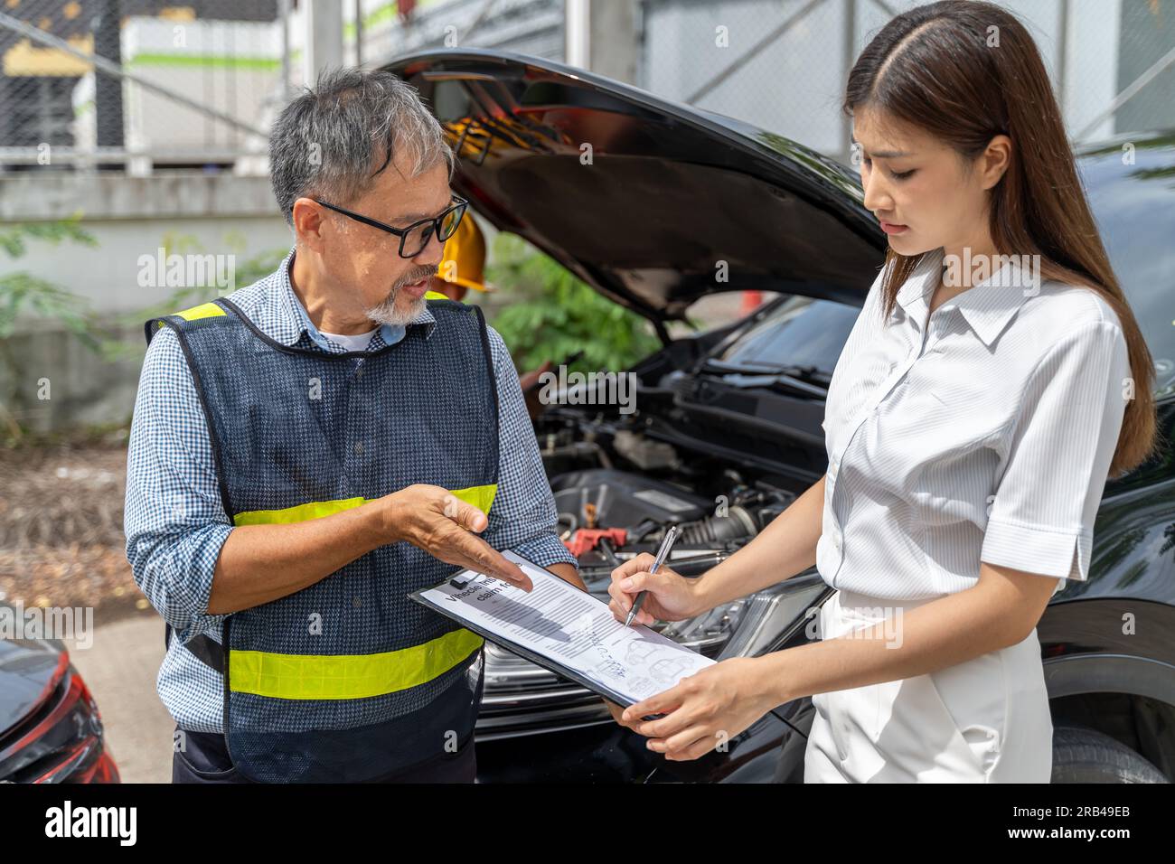a-car-insurance-agent-showing-the-woman-customer-where-to-sign-the-car