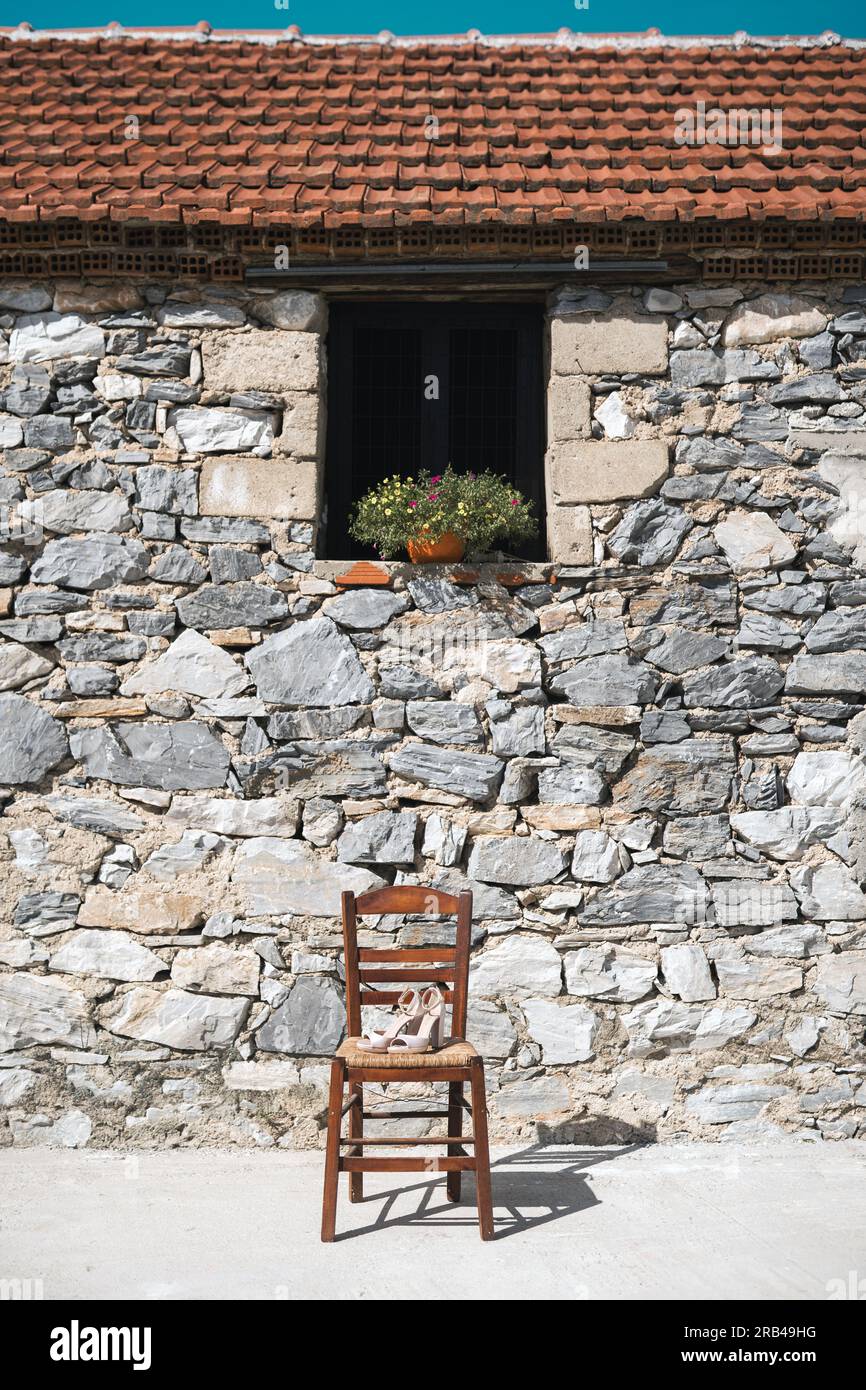 Traditioneller Holzstuhl vor einer Steinwand in Griechenland Stock Photo