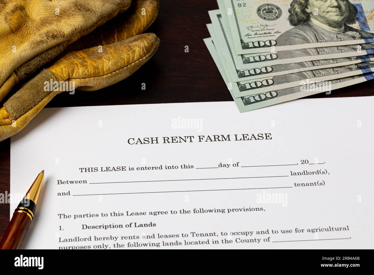 Cash rent farm lease document with leather work gloves. Farming