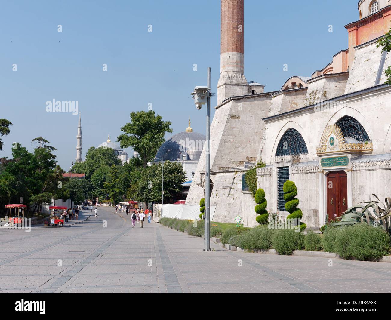 Part of the Hagia Sophia Mosque right and the Sultanahmet Sqaure including red carts selling Simits aka Turkish Bagels, Istanbul, Turkey Stock Photo