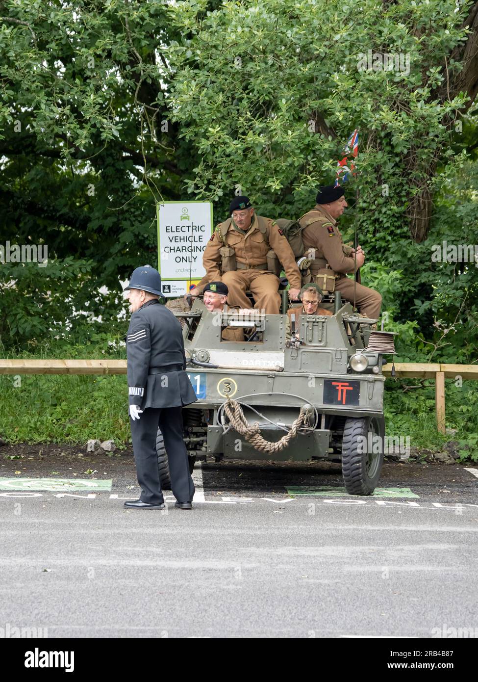 An armoured vehicle parked in an electric vehicle charging bay at the