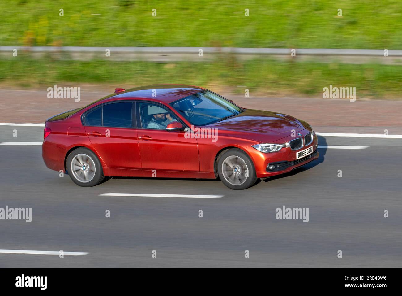 2018 BMW 320D Xdrive Se Auto 320D Xdrive 190 Step Auto Start/Stop Orange Car Saloon Diesel 1995 cc travelling at speed on the M6 motorway in Greater Manchester, UK Stock Photo