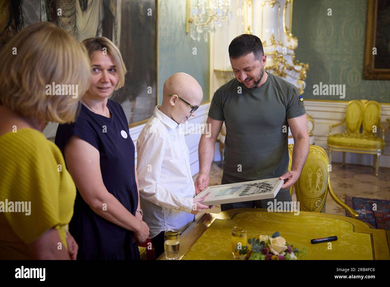 Prague, Czech Republic. 06th July, 2023. Ukrainian President Volodymyr Zelenskyy, right, presents an autographed collection of stamps with the hero bomb sniffing dog Patron for 14-year-old Ukrainian Anton Kotsk, center, at Prague Castle, July 6, 2023 in Prague, Czech Republic. Kotsk has been in Prague since March 2022 for speciality medical treatment. Credit: Ukraine Presidency/Ukraine Presidency/Alamy Live News Stock Photo
