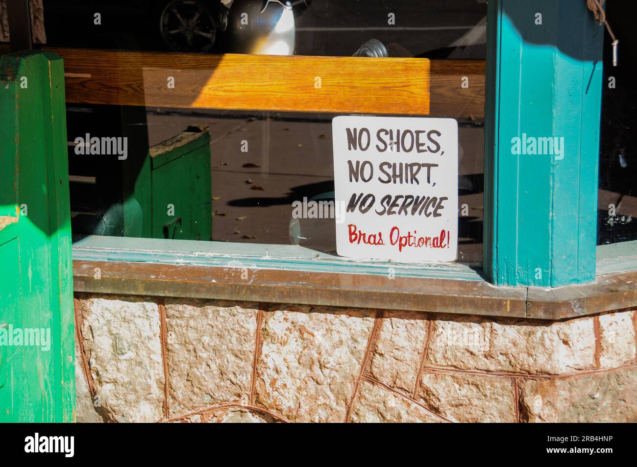 Cheeky 'No Shoes, No Shirt, No Service - Bras Optional!' sign in storefront in Manitou Springs, Colorado Stock Photo