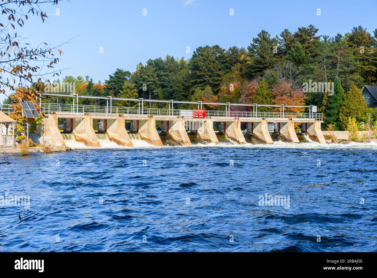 Small dam for flood control on a river on a clear autumn day Stock Photo