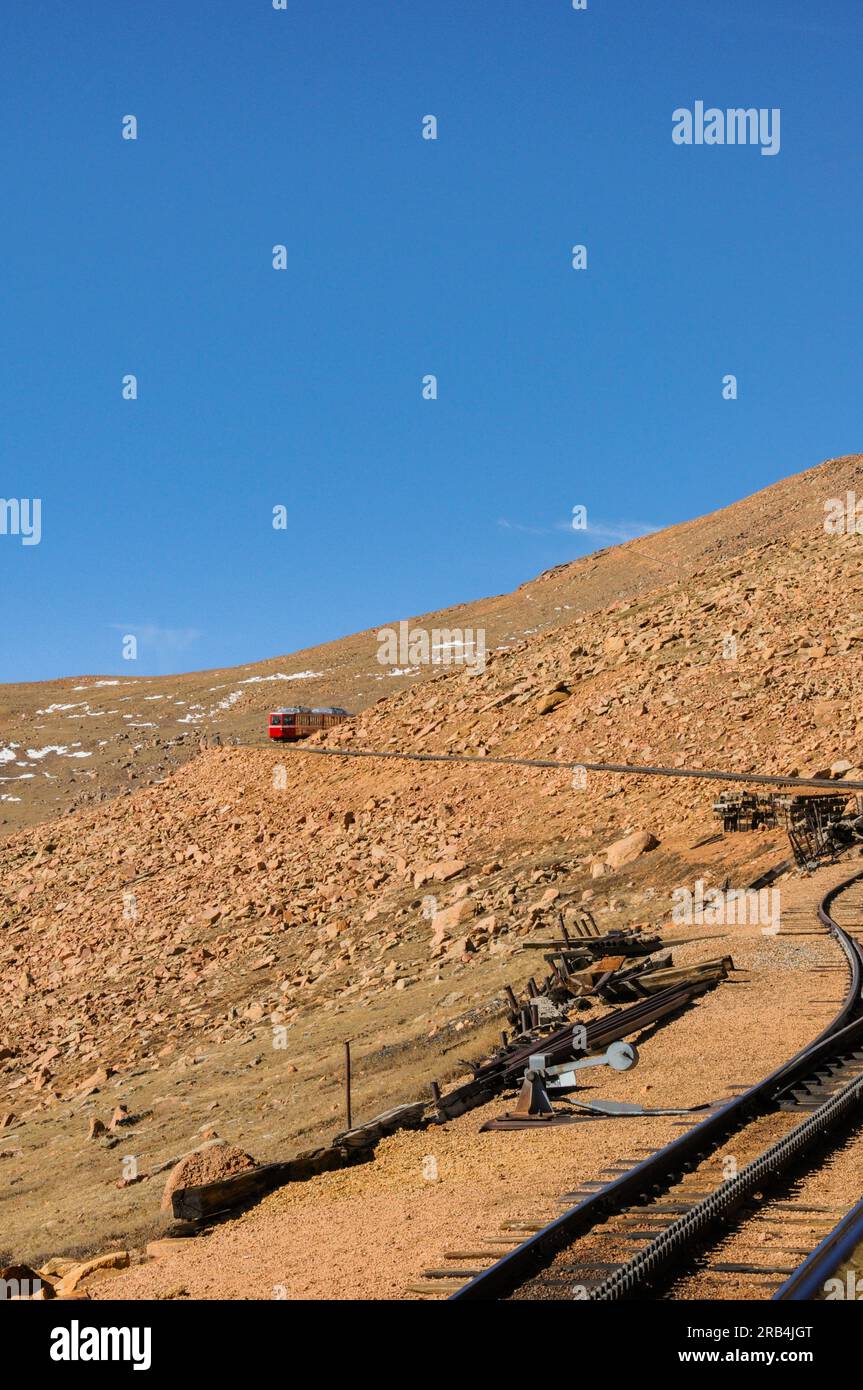 Red cog railway train car descending Pike's Peak mountain in Colorado, USA Stock Photo
