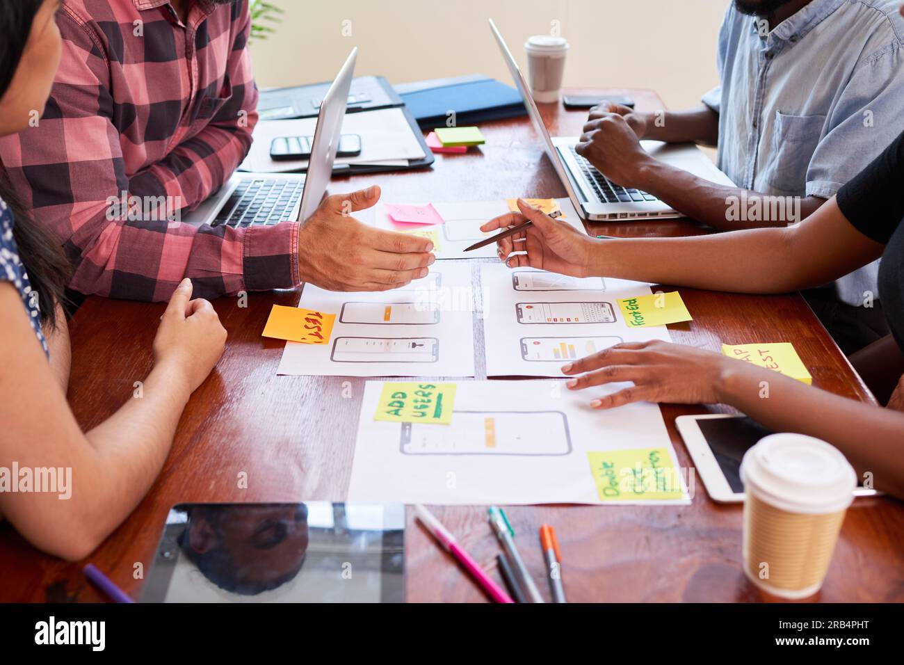 Close up of hands writing notes on mobile app layout design, coding ...