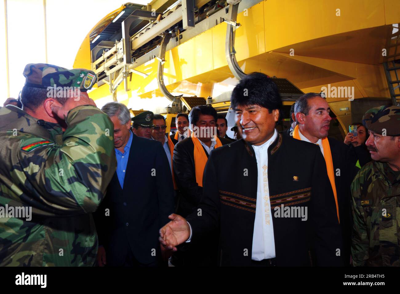 El Alto, Bolivia, 15th September 2014. Bolivian president Evo Morales (centre) greets an army officer as he arrives at the station in Ciudad Satelite for the inauguration ceremony of the Yellow Line. The Yellow Line is the second of three cable car lines to be opened this year, and is part of an ambitious project to relieve traffic congestion. The first line opened in May, when all three are open they will be the world's longest urban cable car system. The system has been built by the Austrian company Doppelmayr. Stock Photo