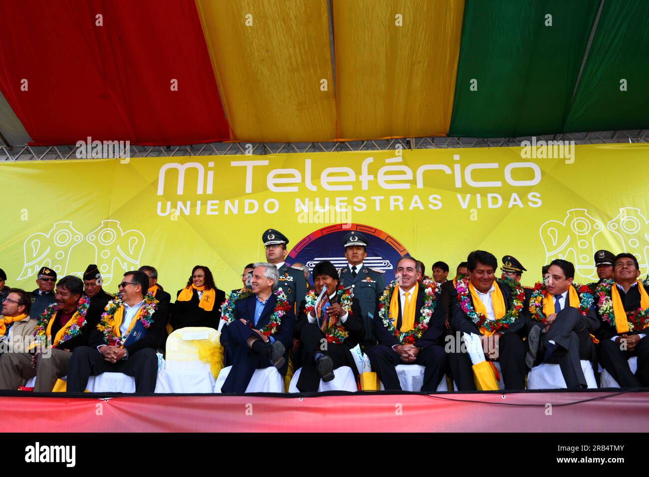 El Alto, Bolivia, 15th September 2014. Bolivian president Evo Morales (centre) and vice president Alvaro Garcia Linera (left centre) at the station in Ciudad Satelite during the inauguration ceremony of the Yellow Line. The Yellow Line is the second of three cable car lines to be opened this year, and is part of an ambitious project to relieve traffic congestion. The first line opened in May, when all three are open they will be the world's longest urban cable car system. The system has been built by the Austrian company Doppelmayr. Stock Photo