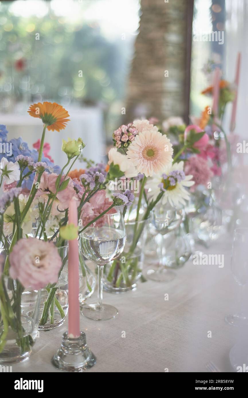 Floristics. Floral decoration of the wedding in pastel colors. Many flowers in different vases and vessels Stock Photo