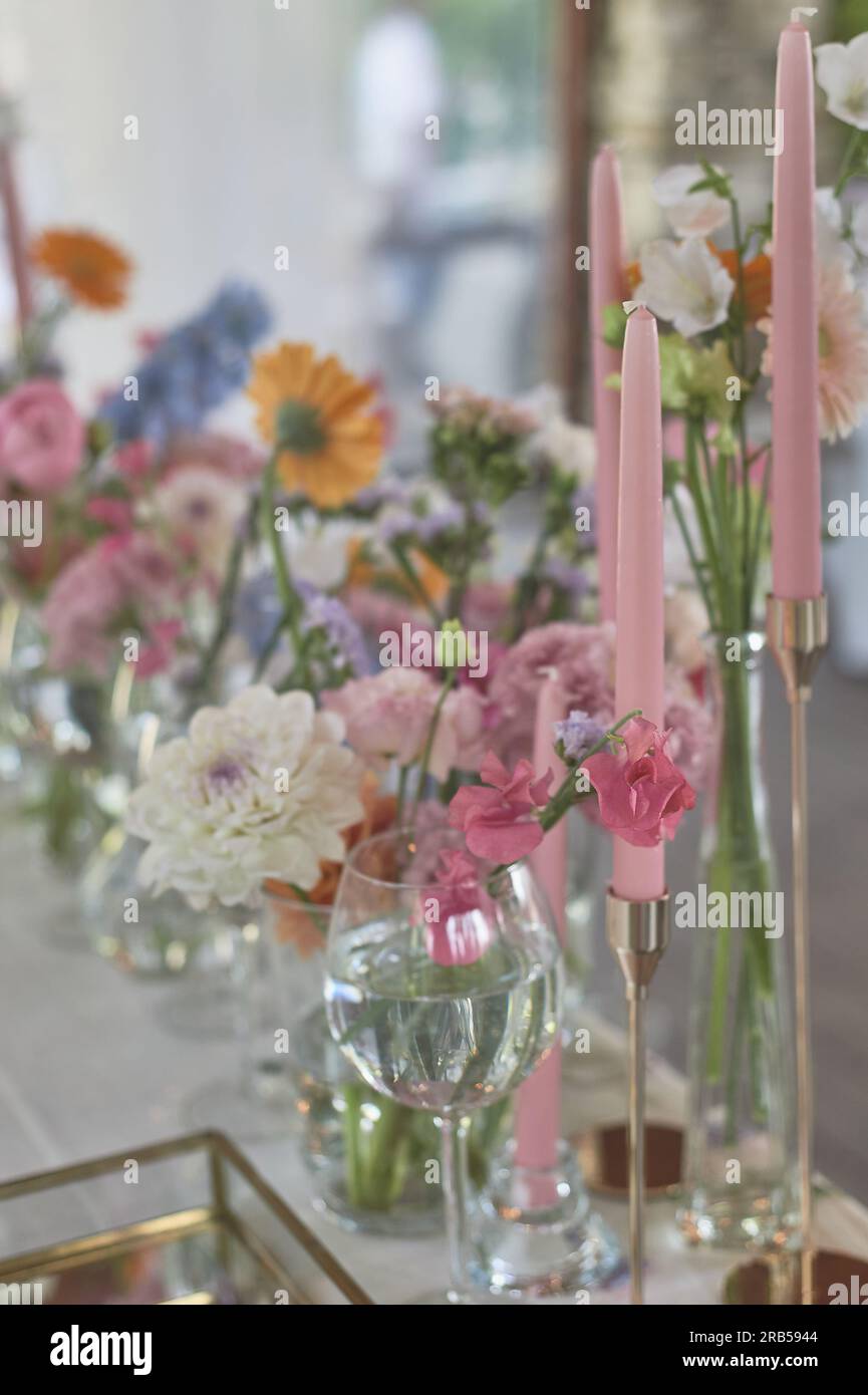 Floristics. Floral decoration of the wedding in pastel colors. Many flowers in different vases and vessels Stock Photo