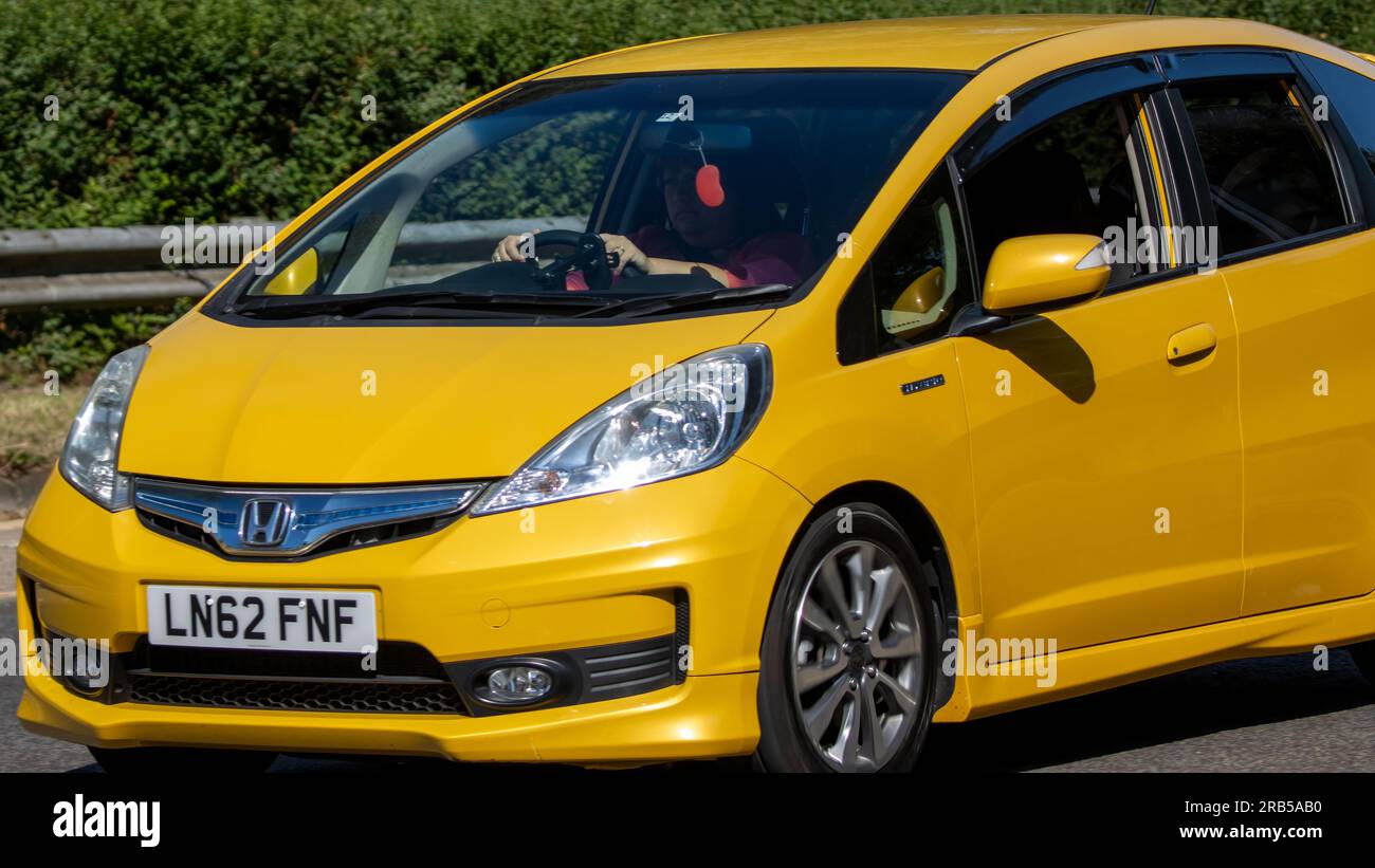 Milton Keynes,UK - July 7th 2023:   Close up of a 2012 yellow Honda Jazz  car travelling on a UK road Stock Photo